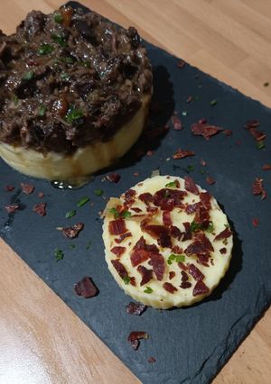 Una foto de Timbal de rabo de toro y puré de patatas con crujiente de jamón