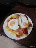 Huevos rotos con papas fritas, pimiento frito y jamón serrano