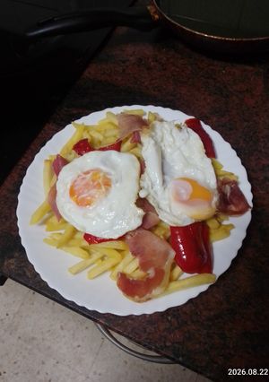 Foto principal de Huevos rotos con papas fritas, pimiento frito y jamón serrano