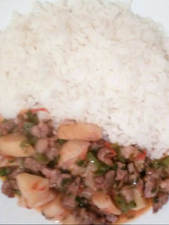 A picture of Potatoes and beef stew served with Rice.