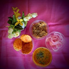 A picture of Dal Bati Churma with pickled onions.