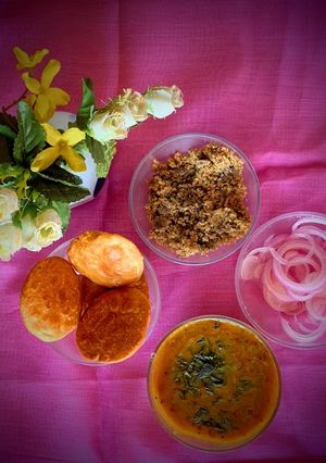A picture of Dal Bati Churma with pickled onions.
