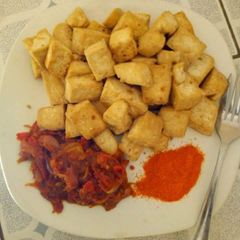 A picture of Fried yam with sauce and dry red  pepper.