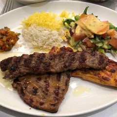 A picture of Rice with grilled meat with stew and salad.
