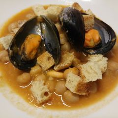A picture of Chickpea and mussel soup with homemade croutons.