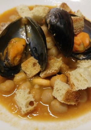 A picture of Chickpea and mussel soup with homemade croutons.