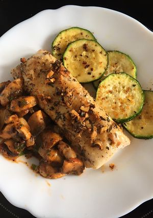 Una foto de Merluza asada con champis y calabacín