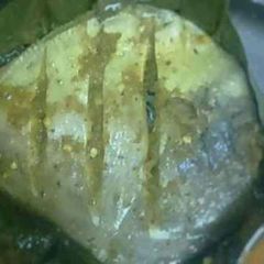 A picture of Pomfret fry wrapped in turmeric leaves.