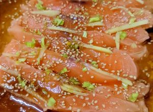 Una foto de Sashimi de salmón con salsa de soja, aceite de sésamo y cítricos