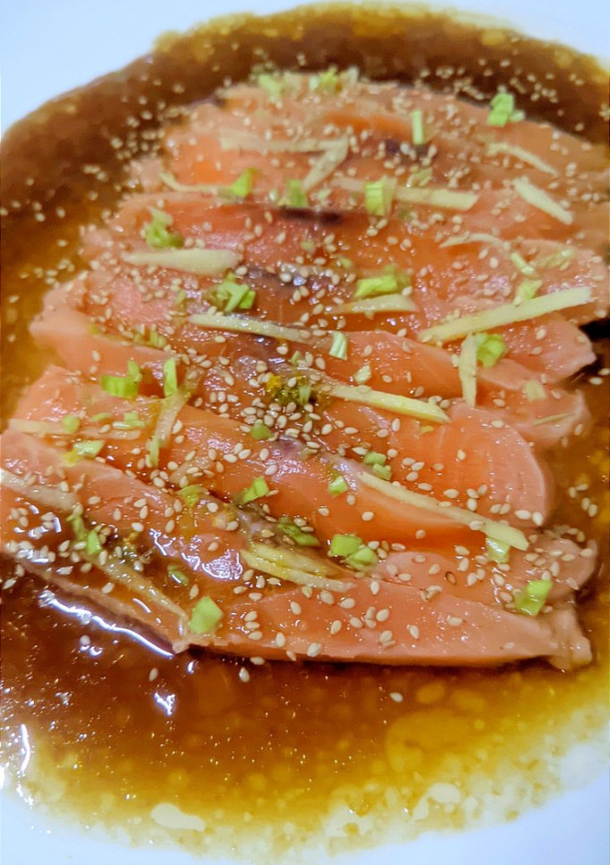 Una foto de Sashimi de salmón con salsa de soja, aceite de sésamo y cítricos