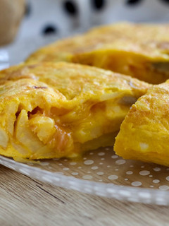 Una foto de Tortilla de patata rellena de jamón serrano y queso