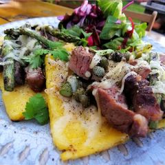 A picture of Open steak polenta sandwich with asparagus and horseradish.