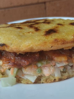 Una foto de Arepa🫓de maíz🌽pelado con carne🍖de cerdo🐖bbq y ensalada🥗