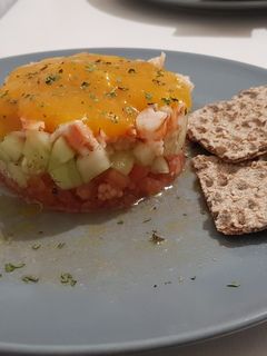 Una foto de Refrescante tartar de gambas, pepino y tomate con coulis de mango
