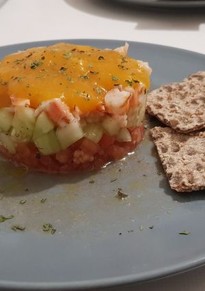 Una foto de Refrescante tartar de gambas, pepino y tomate con coulis de mango