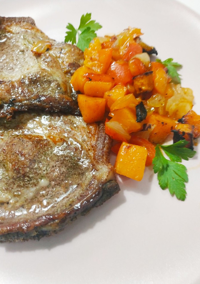 Una foto de Chuletas de cerdo al ajo y perejil con batatas