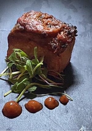 A picture of Pork loin with chorizo and tomato topping.