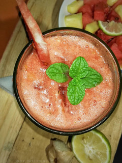 A picture of Watermelon, pineapple smoothie with a touch of fresh mint leaves.