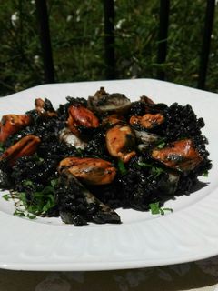 Una foto de Arroz negro con sepia y mejillones