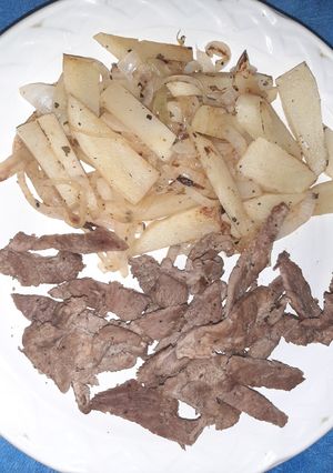 Una foto de Bistec y guarnición de papa y cebolla