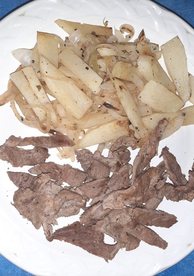 Una foto de Bistec y guarnición de papa y cebolla