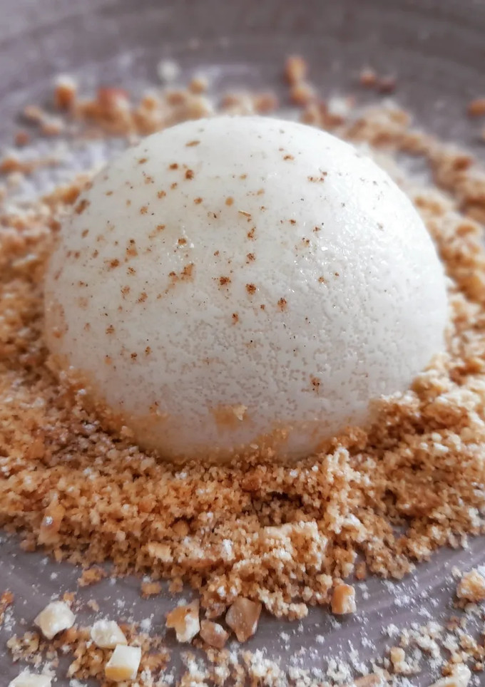 Una foto de Panna cotta de manzana y canela con tierra de galleta
