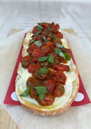 Una foto de Pan pizza con tomates cherry asados, mozzarella y albahaca