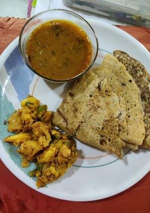 A picture of Bajra ki roti with urad dal and aloo sabzi.