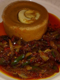 A picture of Moi moi with palm oil sauce.