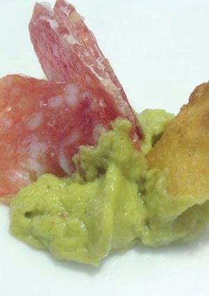 Una foto de Fuet Laminado con espuma de guacamole y crujiente de nachos