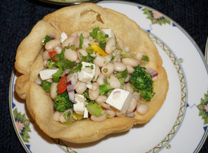 Una foto de Ensalada de porotos blancos con brócoli y queso de cabra en sombrero. Jon style