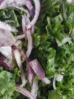Una foto de Ensalada de kale, cebolla morada y maní