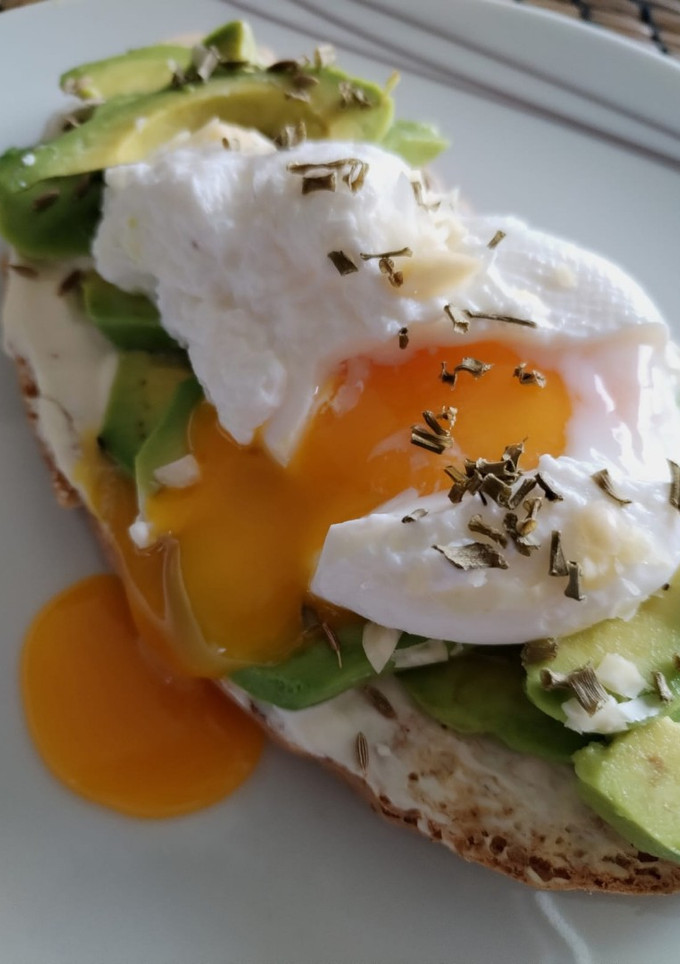 A picture of Avocado Toast with Cream Cheese, Poached Egg, and Sliced Almonds.