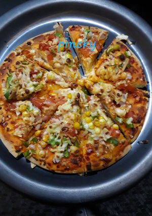 A picture of Onion tomato corn pizza.