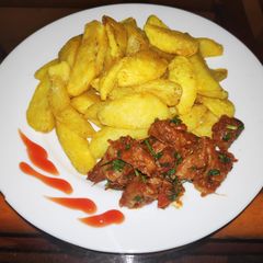 Potato wedges and fried goat meat A picture of Potato wedges and fried goat meat.