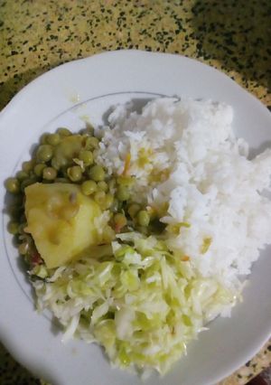 A picture of Rice served with green peas stew.
