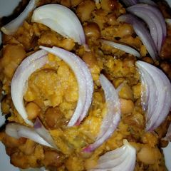 A picture of Beans garnished with onion.