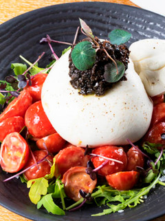 Una foto de Burrata con tomates cherry y Olivada