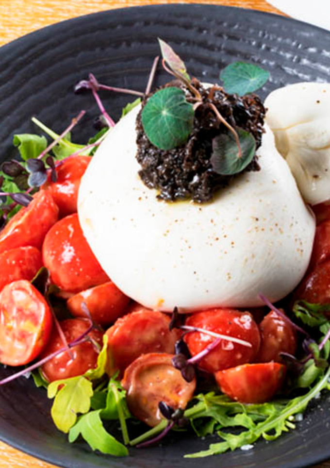 Una foto de Burrata con tomates cherry y Olivada