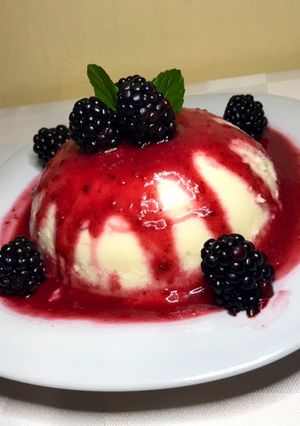 Una foto de Panacota de coco con coulis de zarzamora y canela
