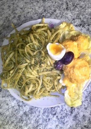 Una foto de Tallarines verdes con papa ala huancaina-comida peruana
