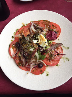 Una foto de Ensalada de tomate con anchoas en salazón, huevo, cebolla y brotes con vinagreta de naranja