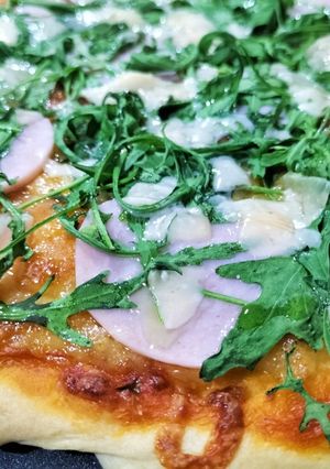Una foto de Pizza trufada de pavo, rúcula y queso tostado