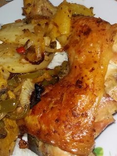 Una foto de Muslo al horno con papas boniato zanahoria y cebolla y morrón