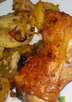 Una foto de Muslo al horno con papas boniato zanahoria y cebolla y morrón