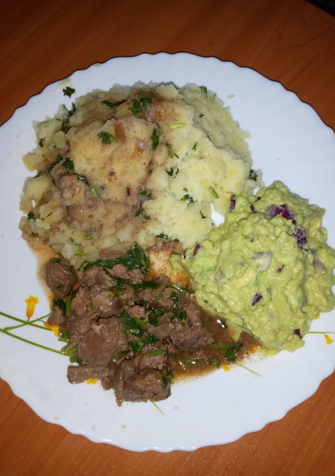 A picture of Beef stew served with mashed potatoes and guacamole.