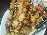Una foto de brochetas de carne con guarnición