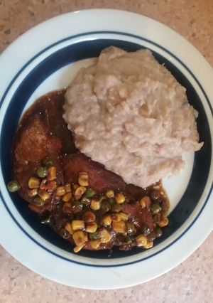 Una foto de Pechugas de pollo al vino con granos de maíz y guisantes verdes