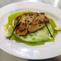 A picture of Peppered Mbuta with garlic mashed potatoes and parsley sauce.
