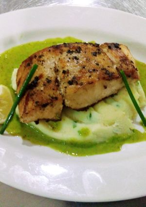 A picture of Peppered Mbuta with garlic mashed potatoes and parsley sauce.